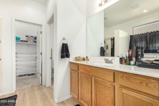 bathroom with hardwood / wood-style flooring, a shower with shower door, and vanity