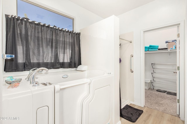 bathroom featuring hardwood / wood-style flooring and plus walk in shower