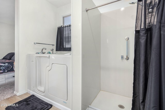 bathroom with hardwood / wood-style flooring and a shower with curtain