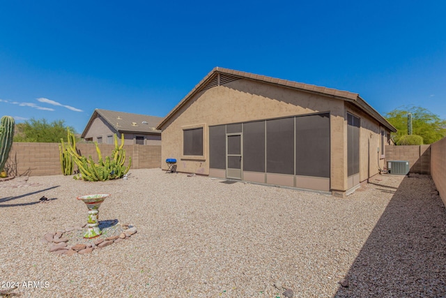 back of property featuring central AC unit, a sunroom, and a patio