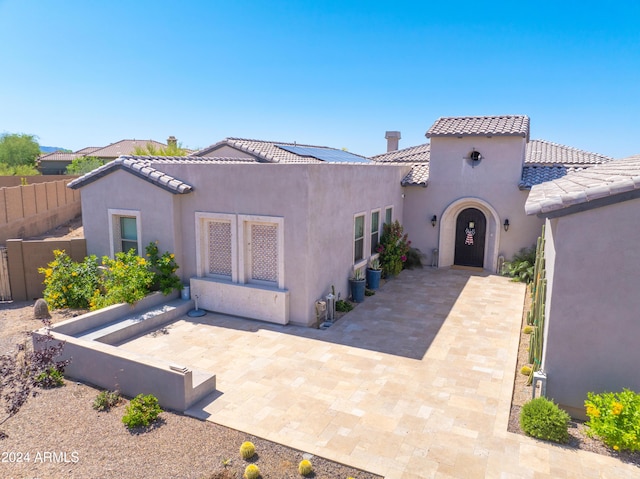 mediterranean / spanish-style house featuring a patio area, fence, a tile roof, and stucco siding