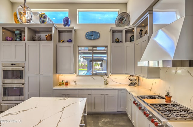 kitchen featuring tasteful backsplash, wall chimney range hood, stainless steel appliances, and open shelves