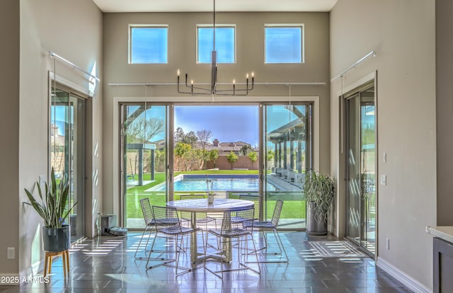 sunroom featuring a chandelier and plenty of natural light