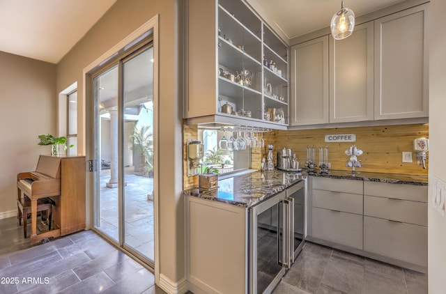 bar with beverage cooler, hanging light fixtures, and baseboards