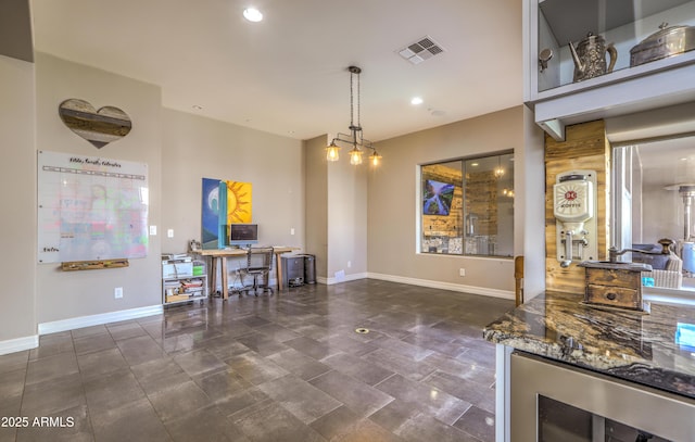 kitchen featuring dark stone counters, wine cooler, visible vents, and baseboards