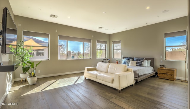 bedroom featuring wood-type flooring, visible vents, baseboards, and multiple windows