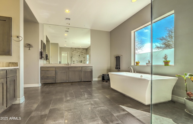 bathroom featuring baseboards, visible vents, vanity, a freestanding tub, and recessed lighting