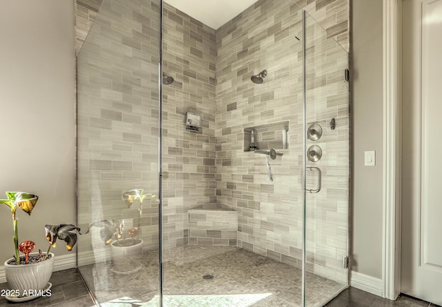 bathroom featuring a shower stall and baseboards