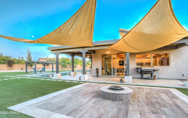 exterior space featuring an outdoor fire pit, a grill, and a pergola