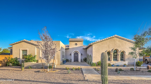 mediterranean / spanish-style house with a tile roof and stucco siding