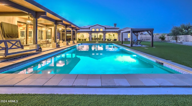 outdoor pool with a lawn, fence, and a patio