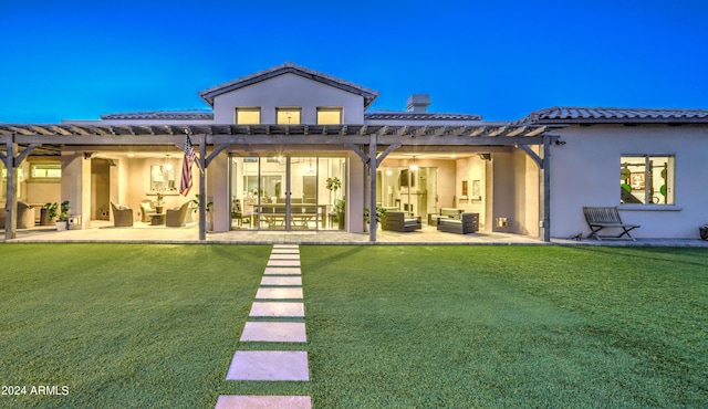 back of house featuring a yard, a patio area, an outdoor living space, and stucco siding