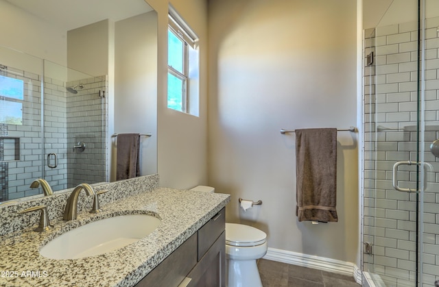 full bathroom featuring baseboards, a shower stall, toilet, and vanity