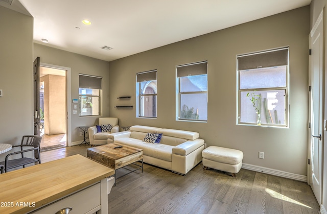 living area featuring hardwood / wood-style flooring, baseboards, visible vents, and recessed lighting