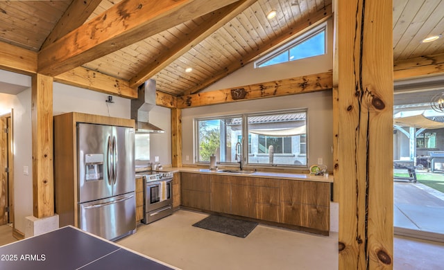 kitchen featuring wall chimney exhaust hood, modern cabinets, appliances with stainless steel finishes, brown cabinets, and a sink