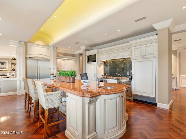 40 Biltmore Est, Phoenix, AZ 85016 - kitchen featuring visible vents, ornamental molding, a sink, light stone counters, and a large island with sink