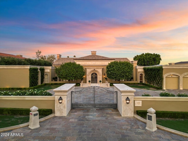 40 Biltmore Est, Phoenix, AZ 85016 - mediterranean / spanish home with a gate, a chimney, stucco siding, a fenced front yard, and a tile roof