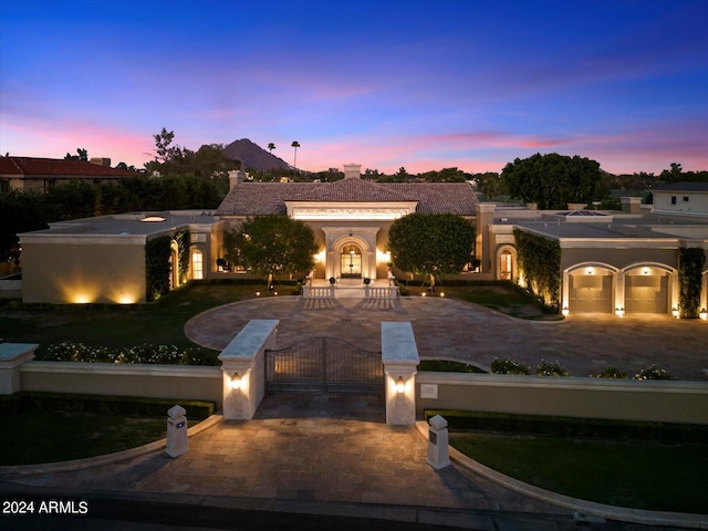 40 Biltmore Est, Phoenix, AZ 85016 - mediterranean / spanish-style house featuring a gate, an attached garage, stucco siding, curved driveway, and a fenced front yard