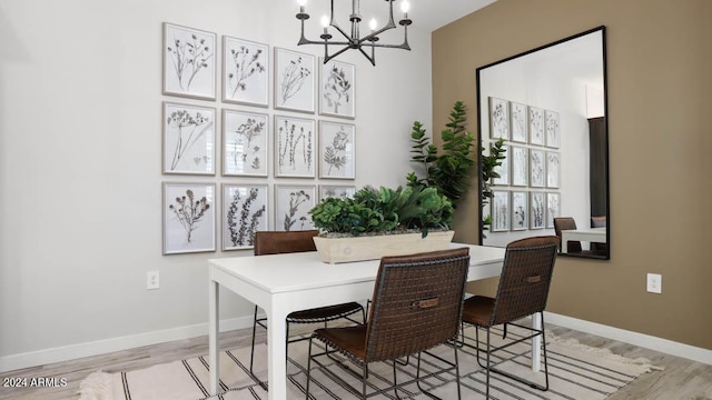 office with light hardwood / wood-style flooring and a notable chandelier