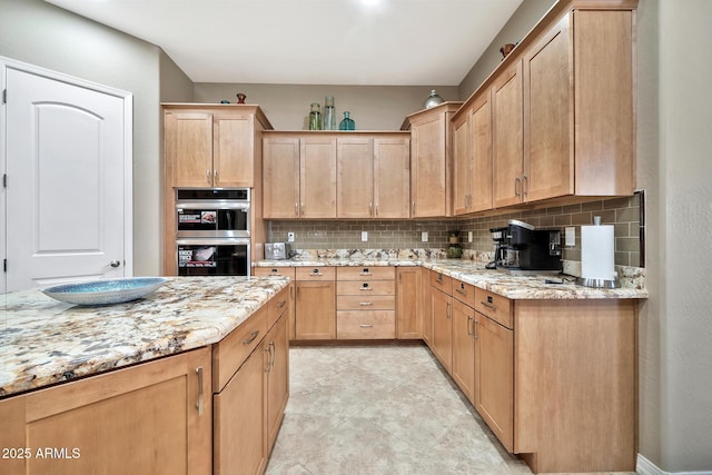 kitchen featuring decorative backsplash, light stone counters, and double oven