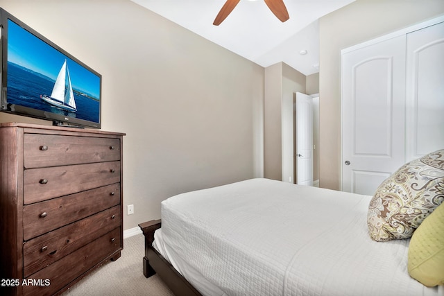 bedroom with ceiling fan, light carpet, and a closet