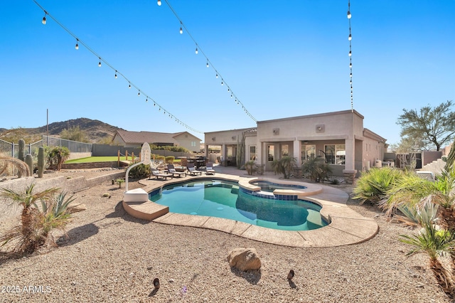 view of swimming pool with a mountain view, a patio area, and an in ground hot tub