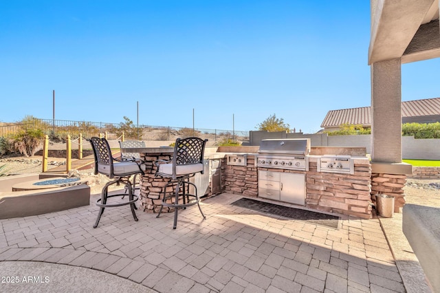 view of patio featuring grilling area, exterior bar, and an outdoor kitchen