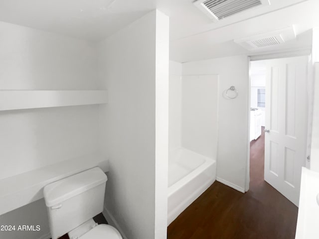 bathroom featuring hardwood / wood-style floors, shower / washtub combination, and toilet