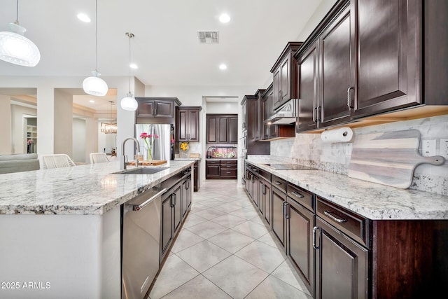 kitchen with pendant lighting, stainless steel appliances, a large island, and sink