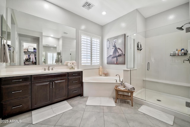 bathroom featuring vanity, plus walk in shower, and tile patterned flooring