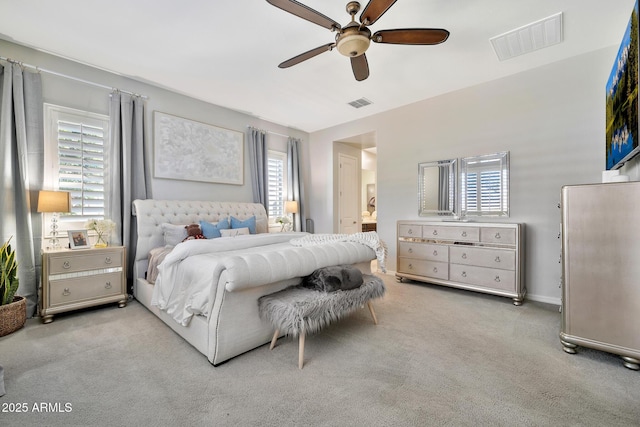 carpeted bedroom with ceiling fan and ensuite bathroom