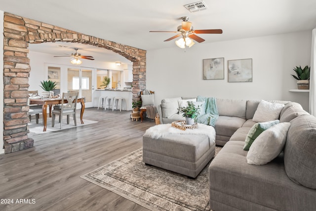 living room featuring hardwood / wood-style floors, ceiling fan, and sink