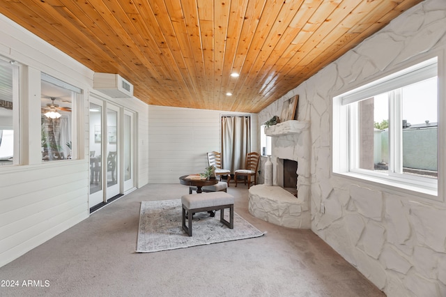 sitting room featuring wood ceiling, ceiling fan, carpet floors, and a fireplace