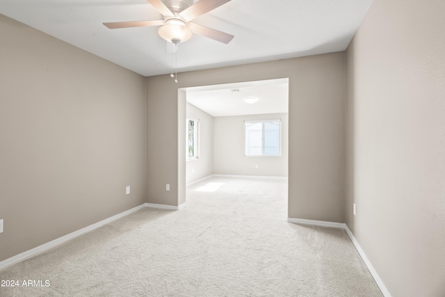 spare room with ceiling fan and light carpet