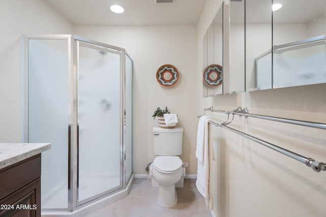 bathroom featuring vanity, toilet, an enclosed shower, and tile patterned floors