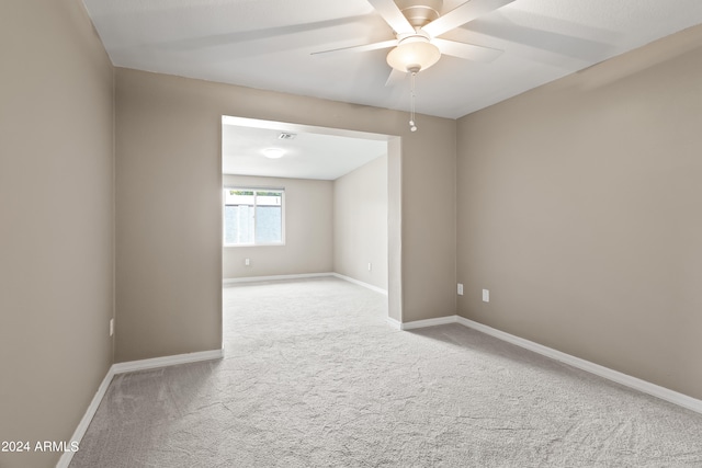 empty room featuring ceiling fan and light carpet