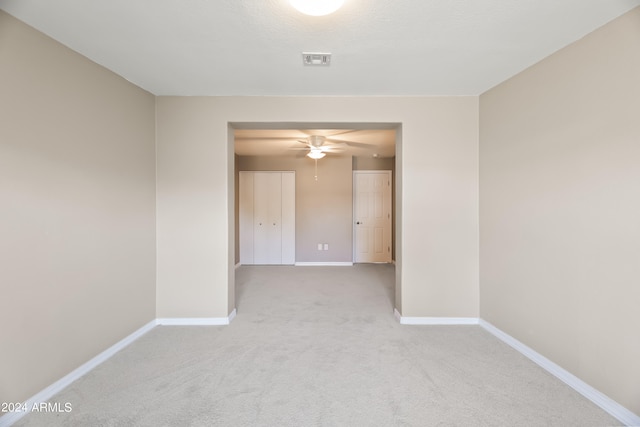 carpeted empty room featuring ceiling fan