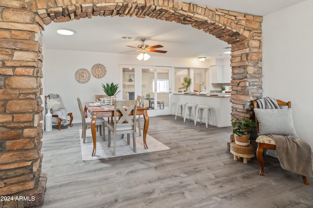 dining space with light hardwood / wood-style flooring, ceiling fan, and sink