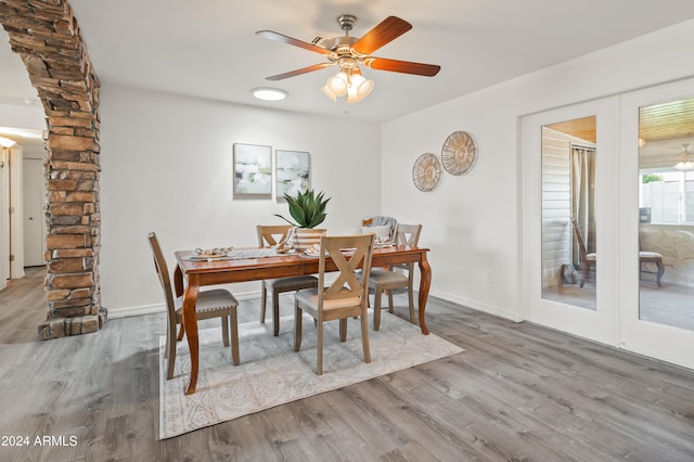 dining area featuring ceiling fan, wood-type flooring, and ornate columns