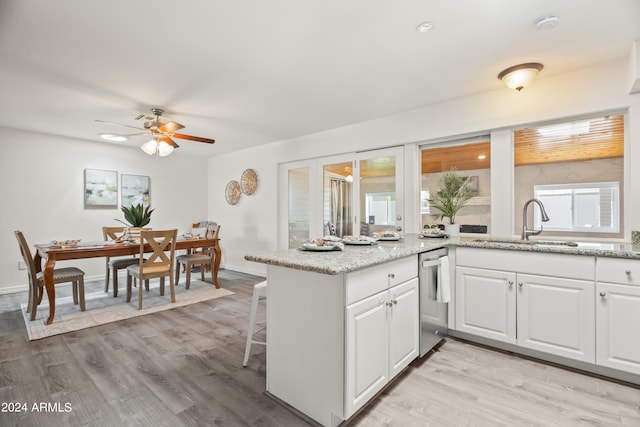 kitchen featuring ceiling fan, plenty of natural light, white cabinetry, and sink