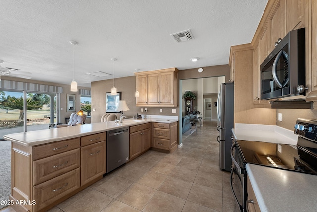 kitchen with visible vents, a peninsula, stainless steel appliances, a textured ceiling, and light countertops