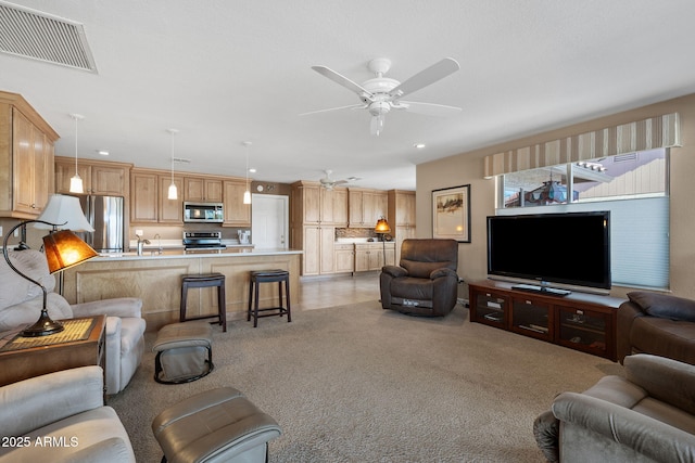 living area with light carpet, visible vents, a ceiling fan, and recessed lighting