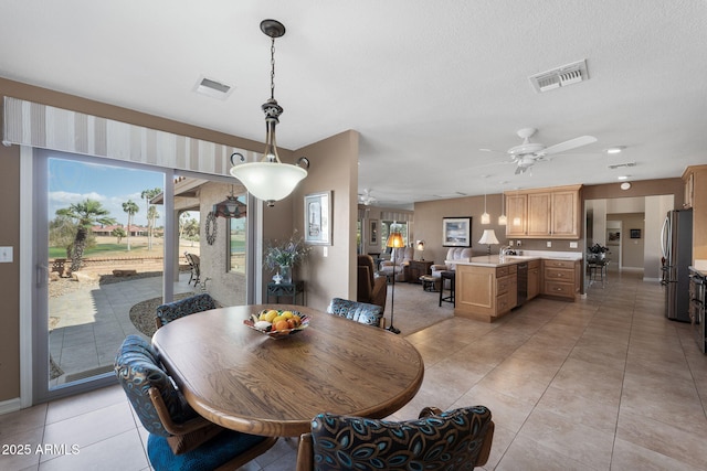 dining area with light tile patterned floors, ceiling fan, visible vents, and a textured ceiling