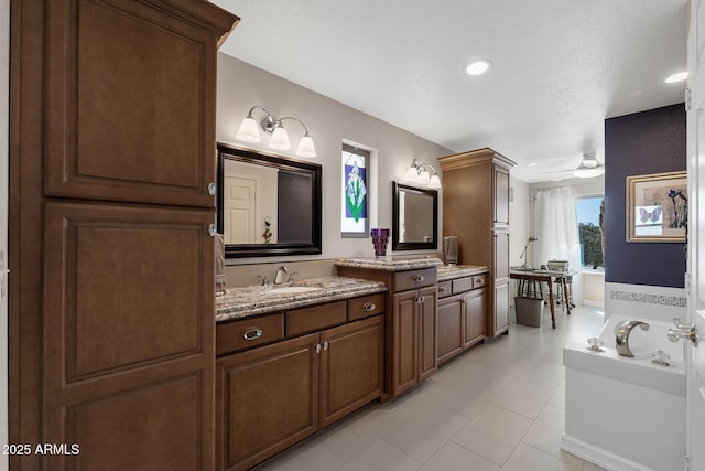 bathroom with a bath, vanity, and a ceiling fan