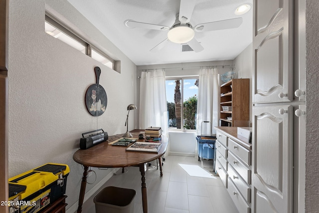 office space with baseboards, light tile patterned flooring, visible vents, and a ceiling fan