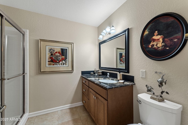 full bath featuring toilet, vanity, a tile shower, and tile patterned floors