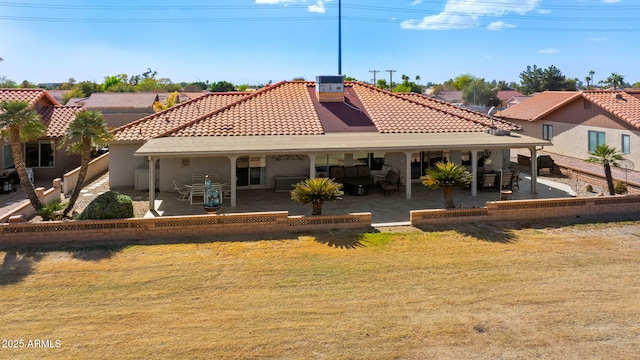 back of house featuring cooling unit, a lawn, a tiled roof, and a patio