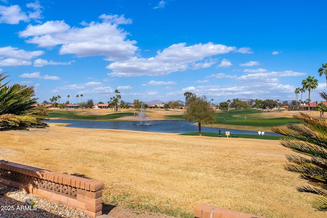 exterior space with view of golf course, a water view, and a yard