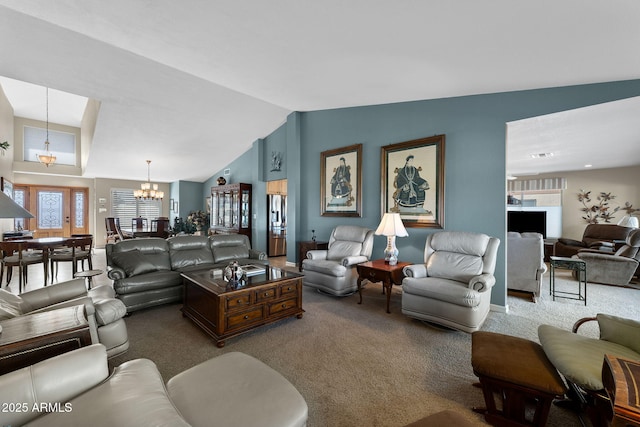 living room featuring lofted ceiling, carpet flooring, and an inviting chandelier