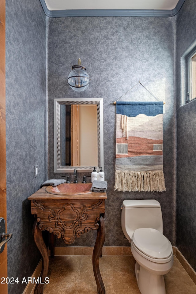 bathroom featuring toilet, vanity, crown molding, and tile patterned flooring